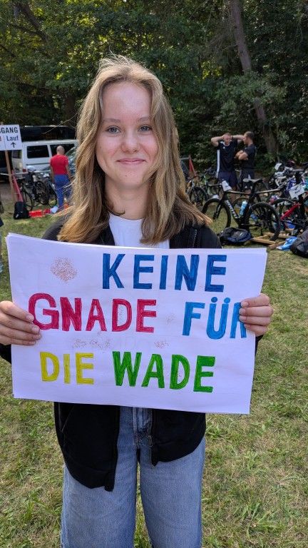 Eine junge Frau mit blonden Haaren hält ein großes Protestplakat mit der Aufschrift KEINE GNADE FÜR DIE WADE.